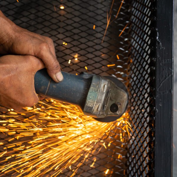 Male workers cut and weld metal with spark.