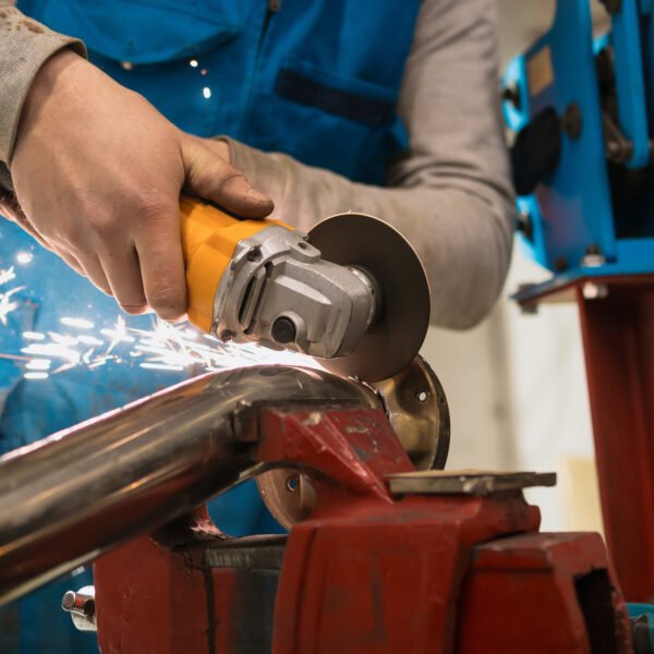 Technician worker cutting metal with many sharp sparks. Using equipments to cat iron
