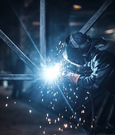 Welding work with metal construction at busy metal factory